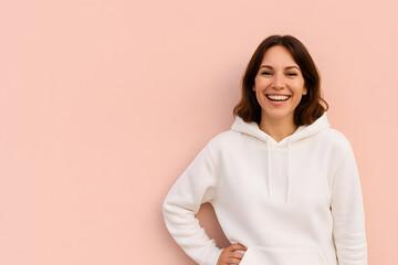 Fototapeta premium Portrait of smiling woman in white hoodie against pink background shot