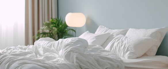 The bed with rumpled white linens in a bright cozy modern bedroom
