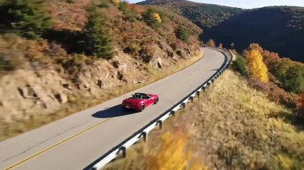Dynamic Aerial Shot of a Luxury Red Sports Car Driving on a Scenic Winding Mountain Road in Autumn.