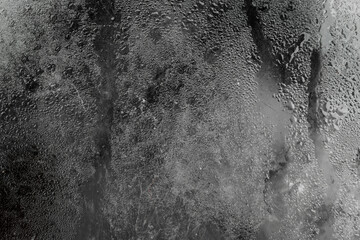 The texture and background of water droplets on the glass surface, forming a natural texture with a blurry effect and soft light sheen