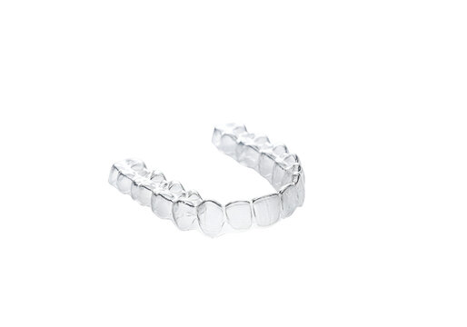 Clear Invisalign dental aligner on black background highlighting orthodontic treatment