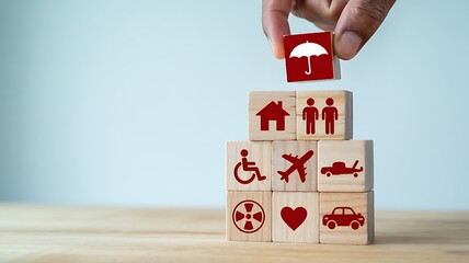Hand stacking wooden blocks with insurance symbols representing home family health disability travel and car protection
