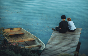 a man and a woman sitting on a small boat dock