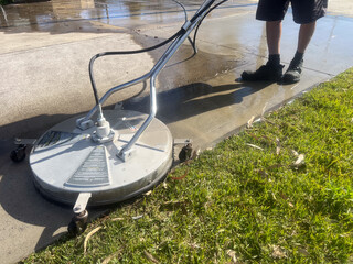 Worker using a floor and surface pressure washer cleaner