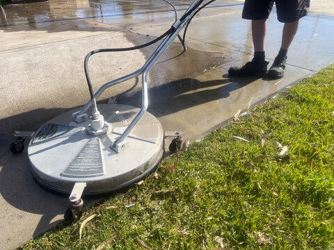 Worker using a floor and surface pressure washer cleaner