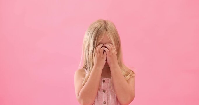 Cute little girl laughing on pink background