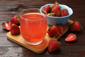 Tasty compot and strawberries on wooden table, closeup