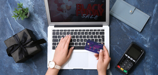 Woman with credit card and laptop shopping online on grunge background. Black Friday Sale