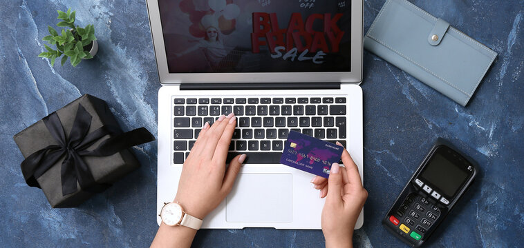 Woman with credit card and laptop shopping online on grunge background. Black Friday Sale