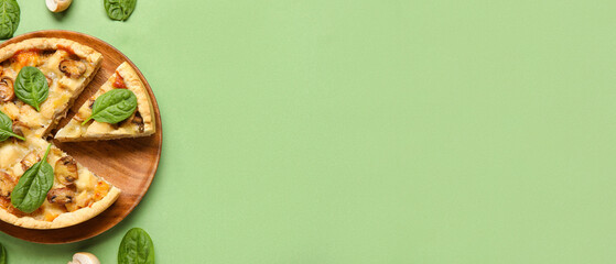 Mushroom pie with spinach leaves and champignons on green background