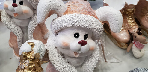 decorative figurine in the form of a funny white rabbit in a winter outfit. The rabbit is dressed...