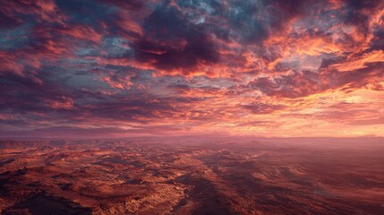 Panoramic view of a fiery sunset over a vast, arid landscape.  A vibrant mix of orange, red, and purple clouds fills the sky, casting a warm glow on the 