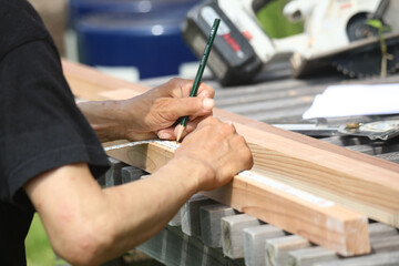 材木に印をつける男性