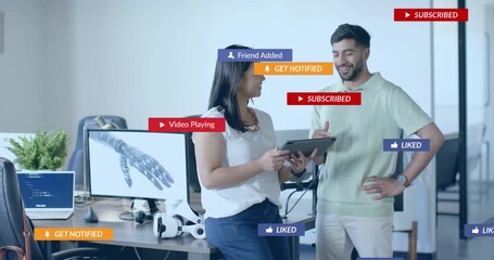 On tapping tablet, woman guiding coworker and activating floating tech icons clustering then fading - Powered by Adobe