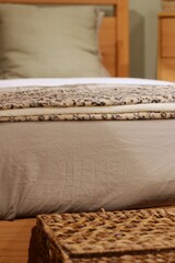 Detalhe de colcha bege e almofada texturizada / Beige bedspread detail with textured pillow
