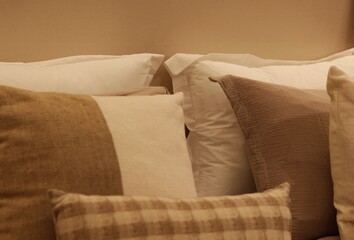 Cama arrumada com travesseiros brancos e bege / Made bed with white and beige pillows