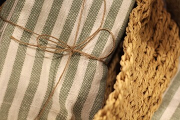 Toalha listrada verde enrolada e amarrada com juta em cesta artesanal de fibra natural / Green striped towel rolled and tied with jute in handmade natural fiber basket