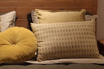 Almofadas geom&eacute;tricas e redonda amarela sobre cama de madeira / Geometric and yellow round pillows on wooden bed