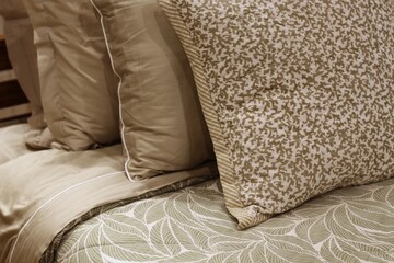 Almofadas bege e florais sobre cama em tons neutros / Beige and floral pillows on neutral tone bed
