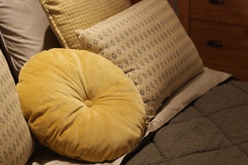 Almofadas decorativas amarelas e estampadas sobre sof&aacute; aconchegante / Yellow round and patterned decorative pillows on cozy sofa