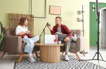 Young woman with man recording podcast in studio
