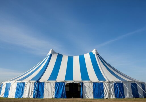 Oktoberfest Large blue and white striped circus tent stands under a clear blue sky with wispy clouds