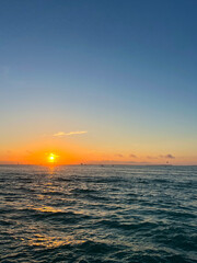 Orange Sun Setting Over Rippling Ocean