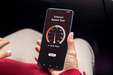 Woman holding a smartphone and checking the internet speed. Internet network connection speed test concept.
