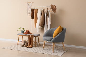 Interior of stylist's studio with clothes rack, armchair and soft bench