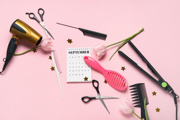 Calendar with hairdresser's tools and tulips on pink background