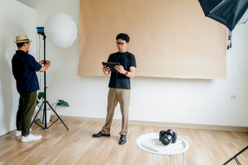 Two Male Doing Studio Preparation Scene With Teamwork Between Lighting And Digital Control