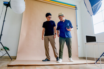 Fototapeta premium Photographer Gives Directions To The Model During A Studio Photo Session