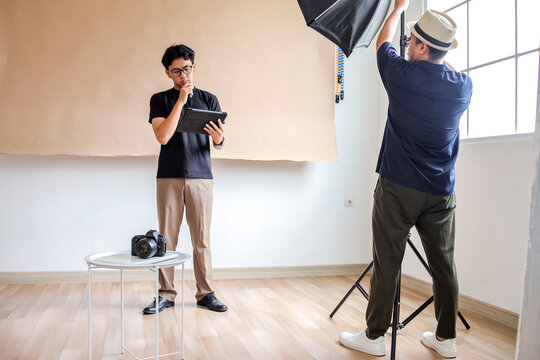 Photography Man Setup Studio for Photo Session With Attention To Lighting And Direction