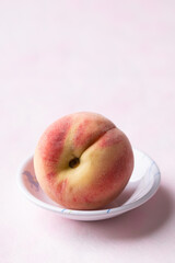 Fresh peach in a bowl on pink background, Summer fruit
