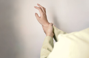 Fototapeta premium Asian business woman massaging wrist in pain caused by working on a computer keyboard for a long time, wrist pain and numbness in the wrist. While working at the office