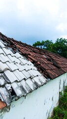 Damaged roof tiles on old house
