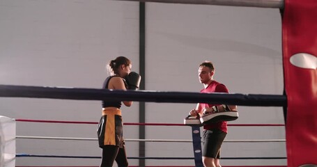 Female boxer following mitts, throwing jabs, crosses, hooks and front kick in ring improving form - Powered by Adobe