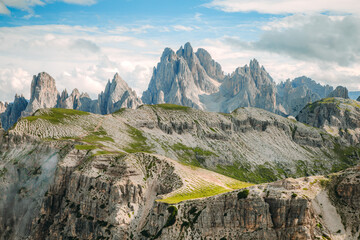 Grassy Slope at Tre Cime di Lavaredo Peaks under Partly Cloudy Sky