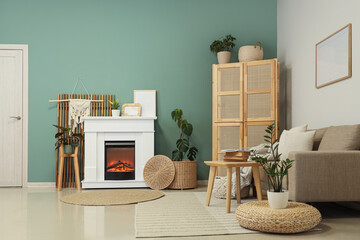 Fototapeta premium Fireplace with sofa, closet and coffee table near turquoise wall in living room