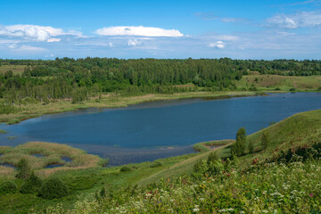 View of the Gorodishchenskoe Lake in Izborsko-Malskaya valley from the Truvorovo settlement on a sunny summer morning, Izborsk, Pechersk district, Pskov region, Russia