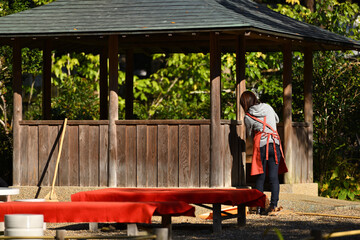 茶屋の落葉を掃く女性