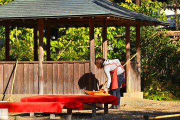 茶屋の落葉を掃く女性