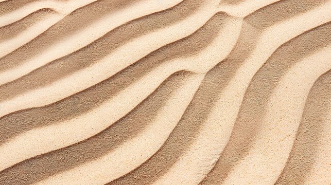 Windblown sand texture with smooth parallel ridges in light brown natural desert patterns showing erosion and geological formation details under sunlight.