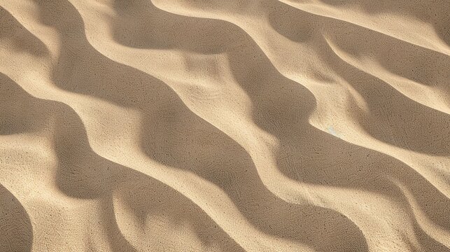Windblown sand texture with smooth parallel ridges in light brown natural desert patterns showing erosion and geological formation details under sunlight.