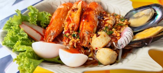 Tom Yum seafood noodles with thick broth, mussels, shrimp, squid, fish balls and soft-boiled eggs.