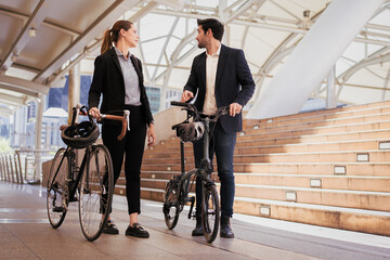 Commuting to work with bicycle. Businessman and businesswoman cycling to office in downtown district. Modern diversity people use eco transportation on city street. Environmental sustainable lifestyle