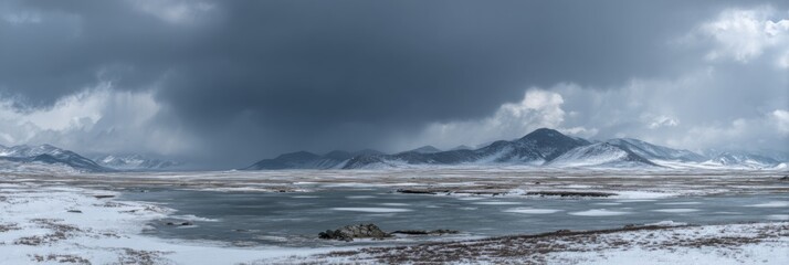 Dramatic Grey Sky Over Snowy Landscape with Frozen Lake and Mountains in Background, Serene Winter Scene