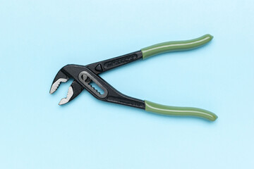 Adjustable Pliers with Green Handles on Blue Surface - Essential Hand Tool for Home Repair and Maintenance