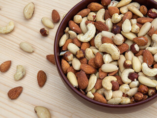Mixed nuts background. Various nuts in a bowl on the table. A healthy snack for energy 