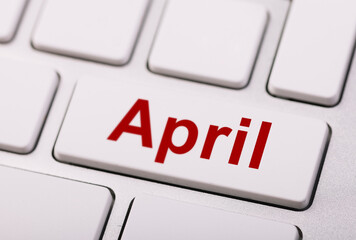 Close-up of a computer keyboard with a key labeled "April" in red, symbolizing digital scheduling and the spring month.